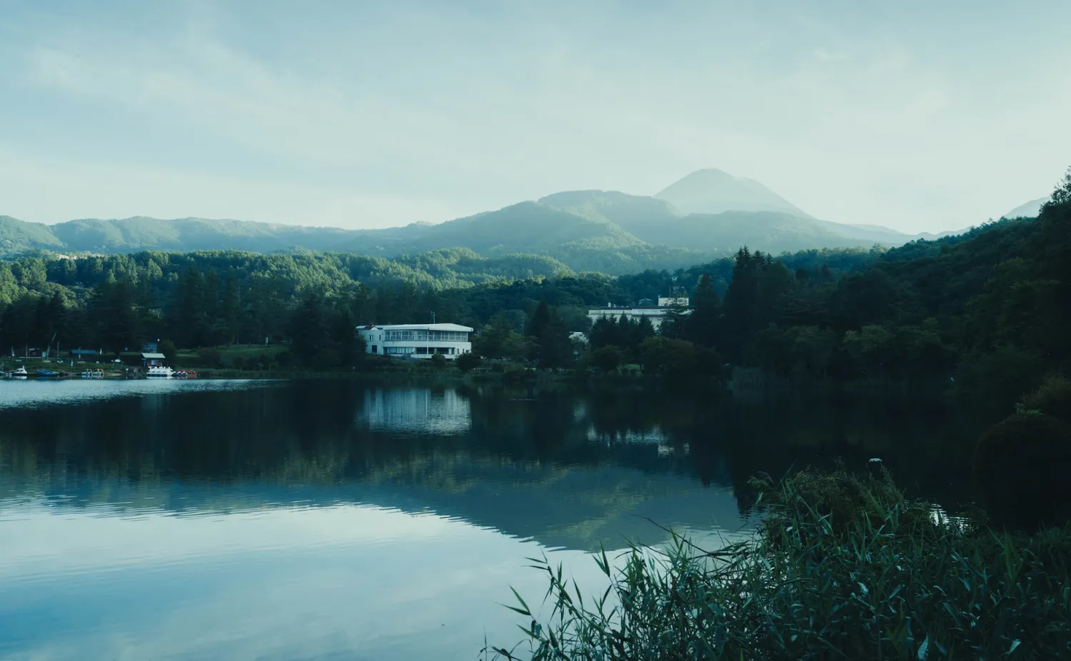 朝霧に浮かぶ白駒池と周囲の山々の絶景